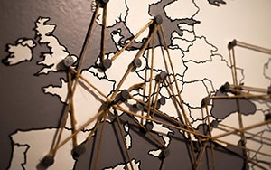 Europkarte mit Stecknadeln und vernetzenden Fäden